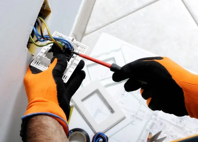 Regulación y domótica de luz Electricista cambiando un interruptor con destornillador aislado