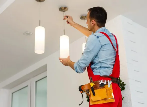 Iluminación de comercios Electricista instalando lámparas colgantes en el techo