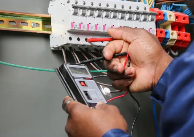 Medición de tensión en las bornas del cuadro eléctrico con multímetro digital · Instalación y motorización de puertas automáticas en Málaga