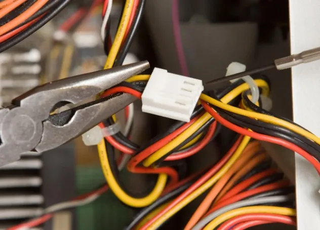 Reparación de conexiones eléctricas con alicates en un mazo de cables en Málaga